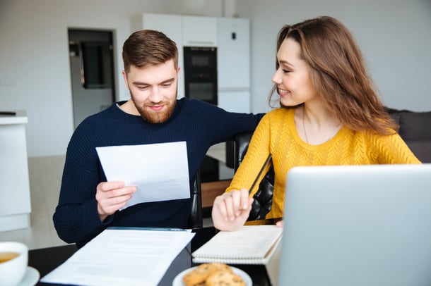 Happy young couple calculating bills at home-2