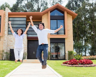 Excited couple jumping after buying a house.jpeg