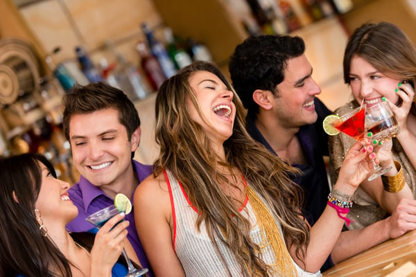 Happy group of friends at the bar having drinks