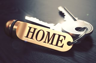 Keys and Golden Keyring with the Word Home over Black Wooden Table with Blur Effect. Toned Image..jpeg